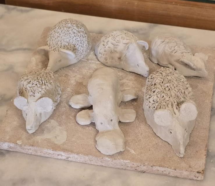 Petits animaux en argile alignés sur une plaque